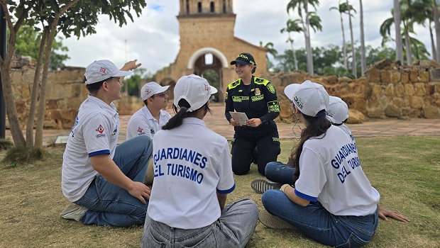 Un funcionario de polic&iacute;a de turismo dialogando con j&oacute;venes del programa guardianes del turismo