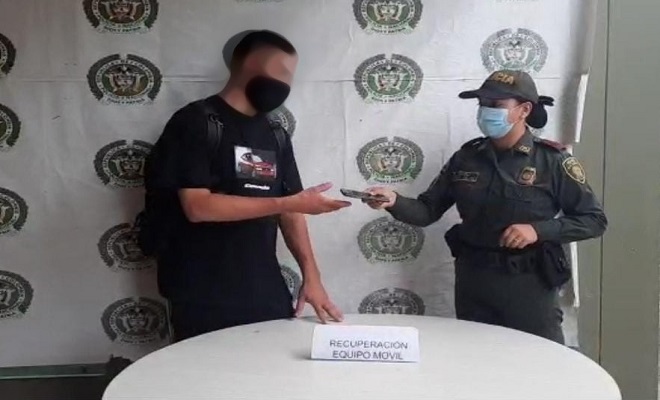 Policía entregando celular recuperado