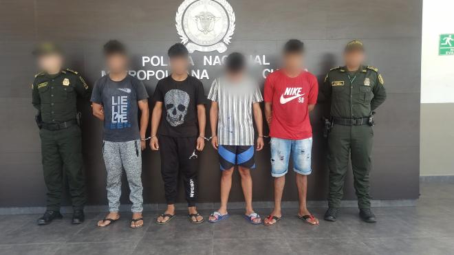 Personas capturadas-policías custodiando