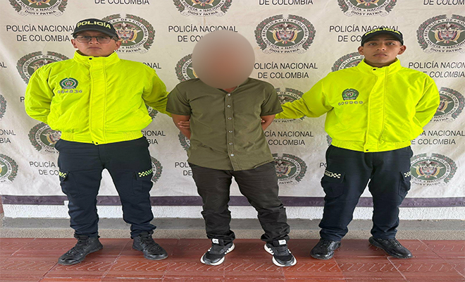Una persona capturada por dos policías por orden judicial