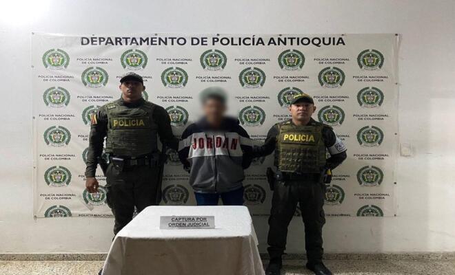 Dos polic&iacute;as custodian a un capturado por orden judicial