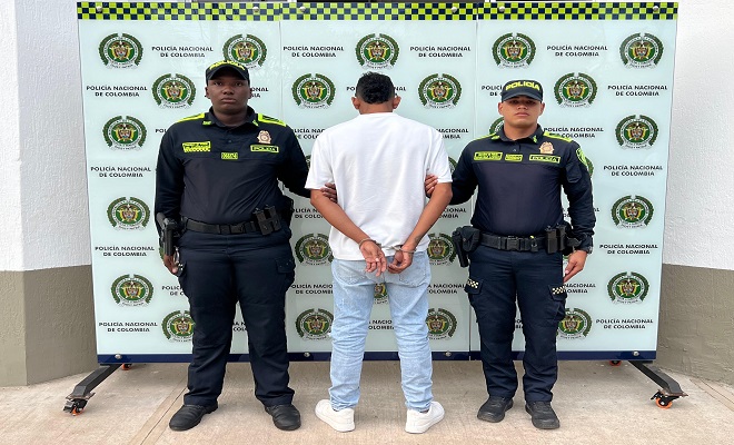 una persona de espalda capturada por delitos sexuales y dos Policías brindando seguridad 