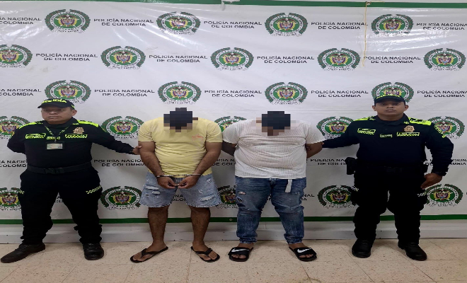 Dos policías con  dos personas Capturadas por hurto.