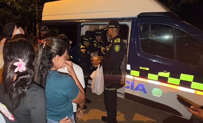 Polic&iacute;as entregan alimentos a la comunidad en un veh&iacute;culo