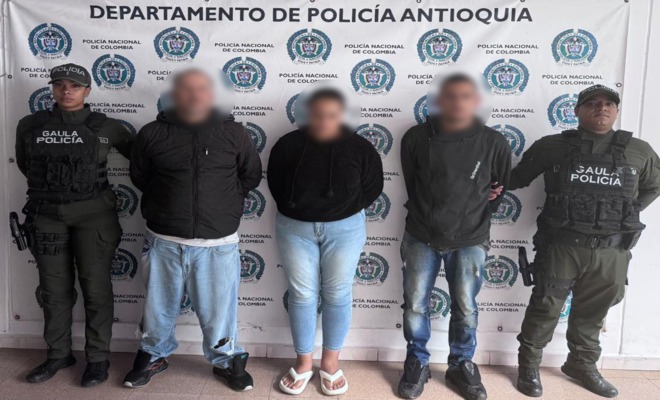 Dos polic&iacute;as del GAULA custodian a dos hombres y una mujer presuntos extorsionistas