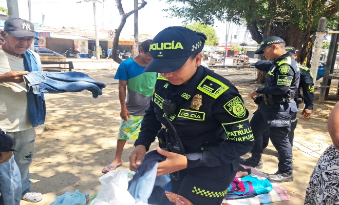 Tres policías y ciudadanos en entrega de prendas de vestir 