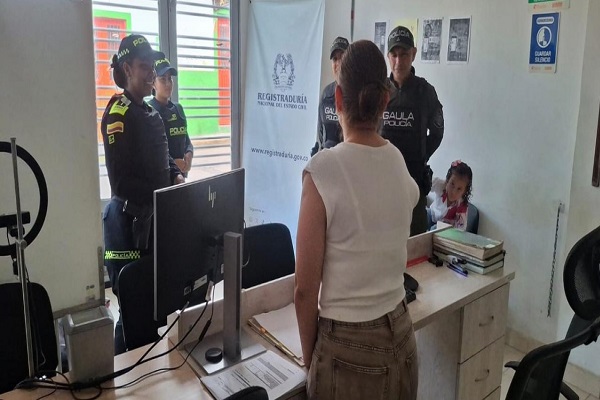 Cuatro Policías compartiendo recomendaciones a funcionaria de la registraduria