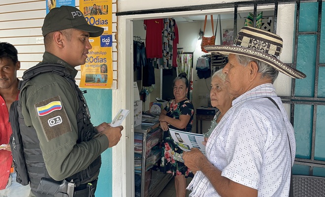 Un policía entregando volantes con información sobre la línea 165 del GAULA