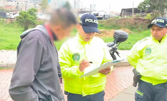 Dos policías realizan a lectura de derechos del capturado a un persona.