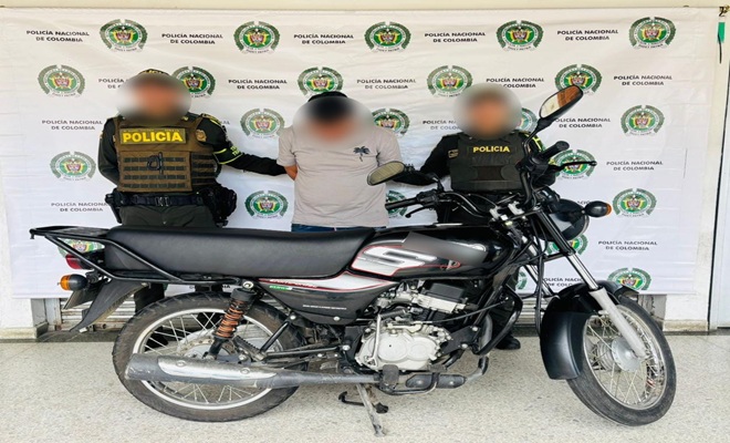 Policías con persona capturada junto a la moto recuperada