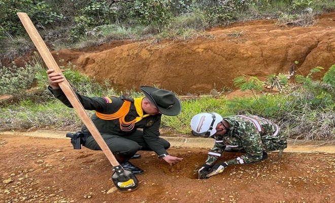 Un Policia de Carabineros y un integrante del Ejercito Nacional siembran un árbol 