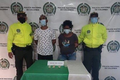 2 personas capturadas-policías custodiando