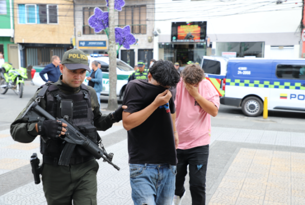 Personas capturadas-policías custodiando 