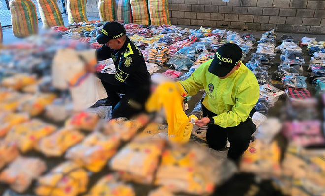Dos polic&iacute;as revisando camisetas incautadas