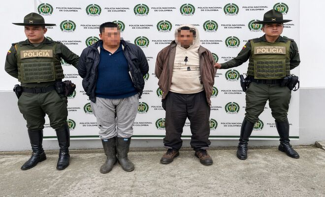 Dos capturados esposados con dos polic&iacute;as de carabineros en cada lado 