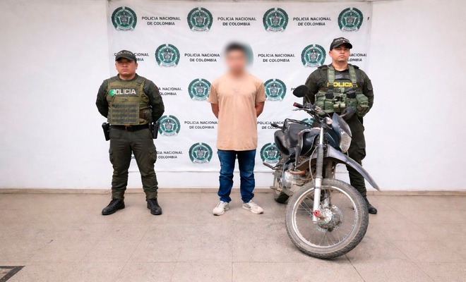 Un ciudadano capturado esposado con dos polic&iacute;as a su lado y una motocicleta recuperada 