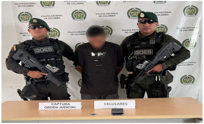 Un hombre capturado esposado con dos Policías del GOES en cada lado  