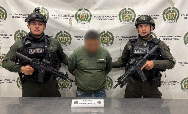 Una persona capturada que se encuentra esposado y a su lado dos polic&iacute;as del GOES
