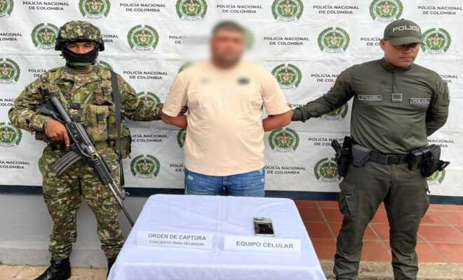 Un soldado y un polic&iacute;a custodian a un capturado alias mono