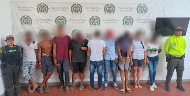 Personas capturadas-policías custodiando
