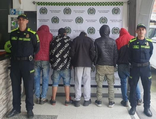 Personas capturadas-policías custodiando