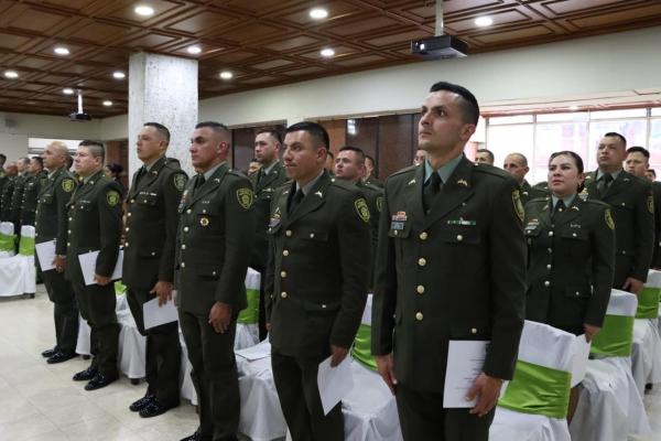 El personal de validadores de pie en acto protocolario con los certificados en la mano izquierda