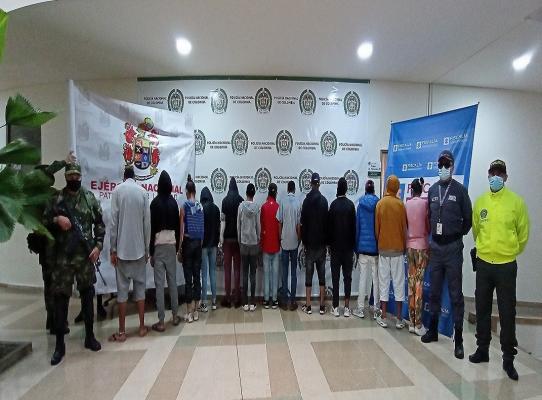 13 personas capturadas-policías custodiando