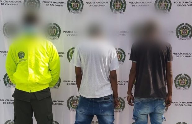 2 personas capturadas-policías custodiando