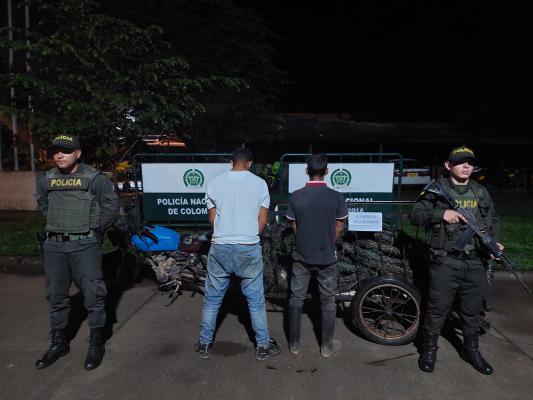 Dos hombres capturados-policías custodiando