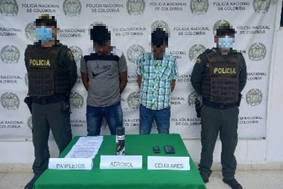 2 personas capturadas-policías custodiando