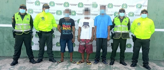 Personas capturadas-policías custodiando