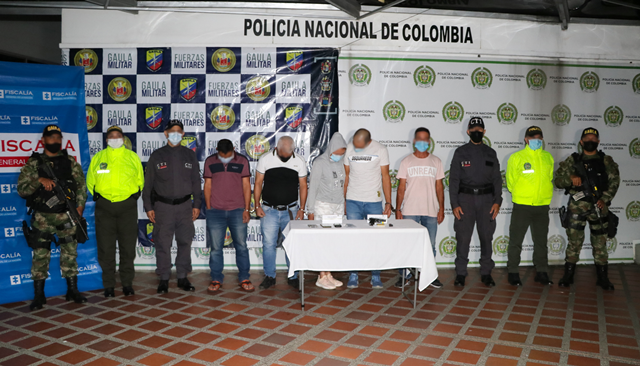 Personas capturadas-policías custodiando