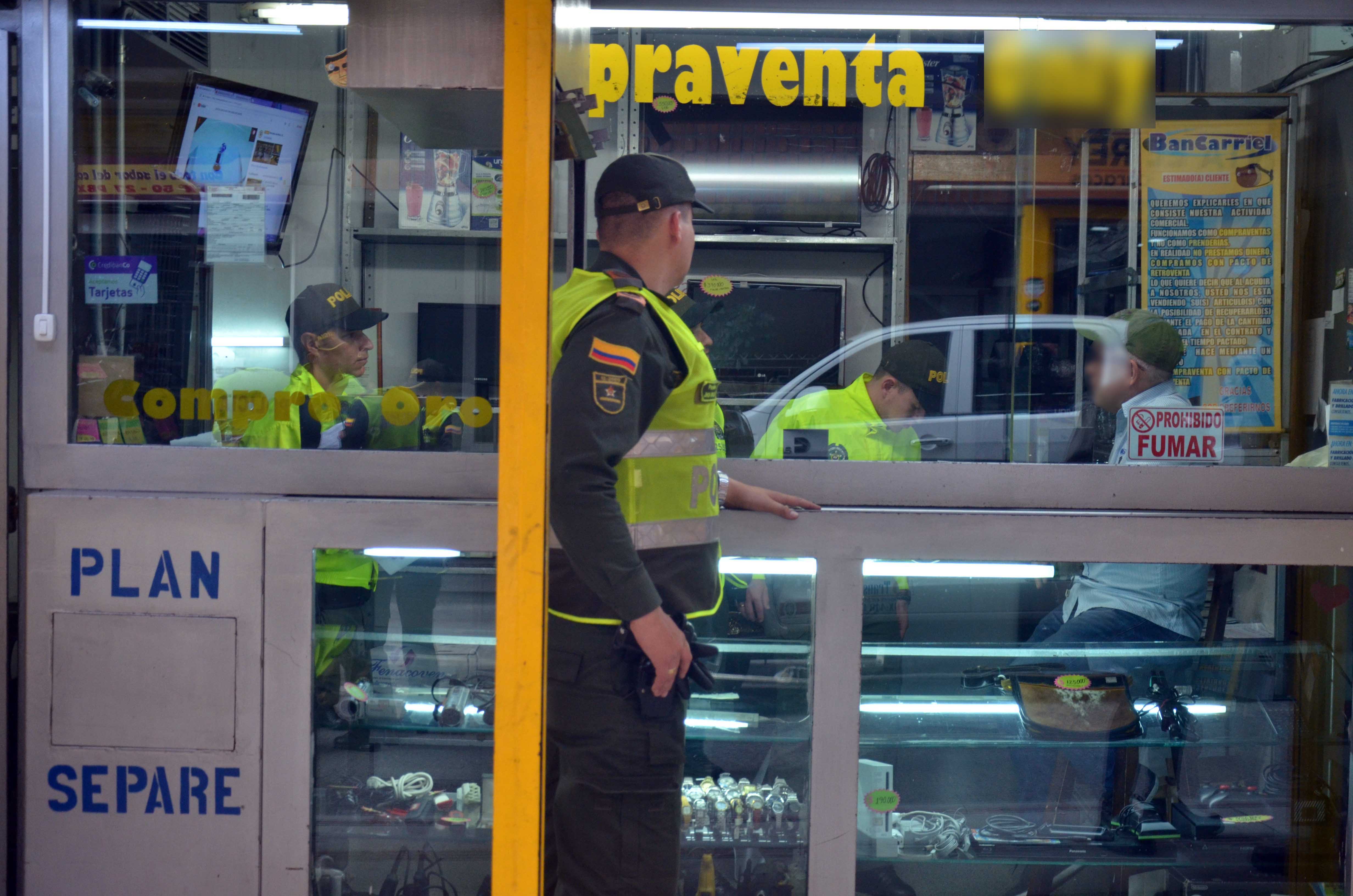 Policías inspeccionan elementos al interior de compraventa