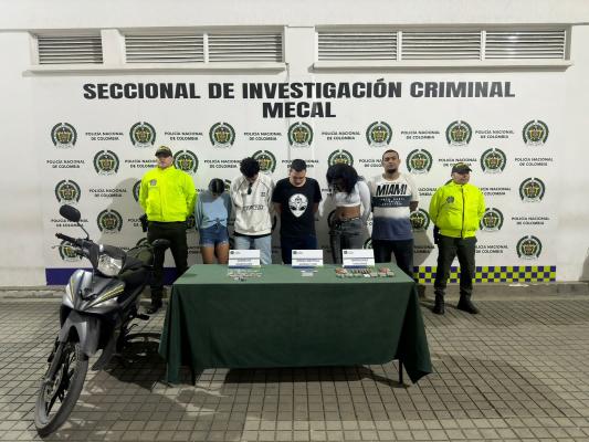 Personas capturadas-policías custodiando