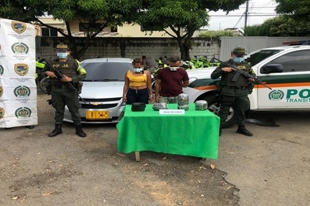 dos personas capturadas-policías custodiando-alucinógenos incautados 