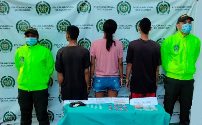 Personas capturadas-policías custodiando