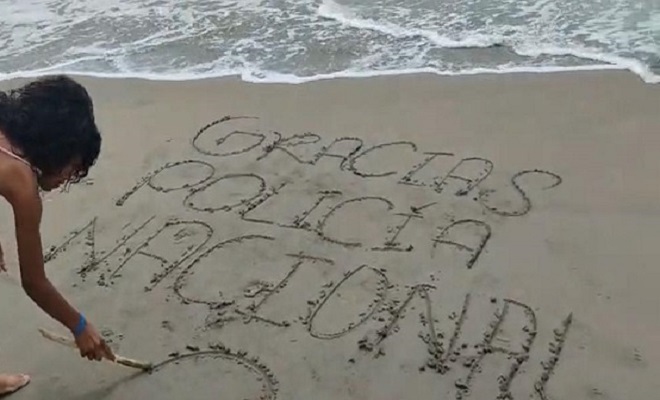 niña dibuja sobre la arena 