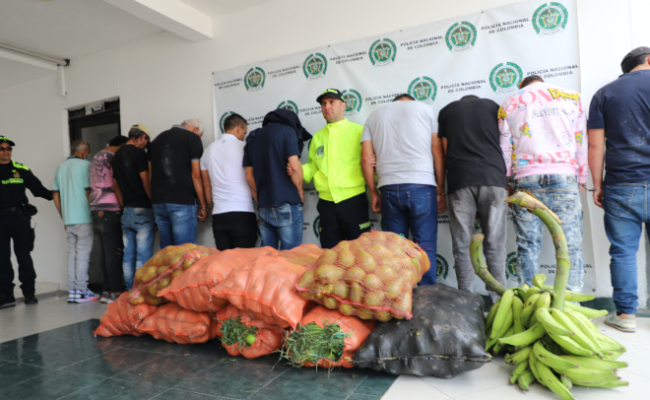 Personas capturadas-policías custodiando