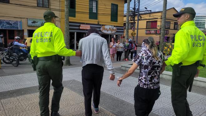 Personas capturadas-policías custodiando