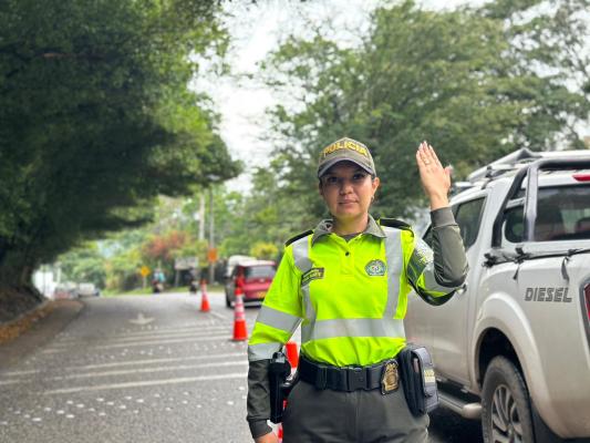 Mujer Policia en la v&iacute;a en puesto de control a vehiculos