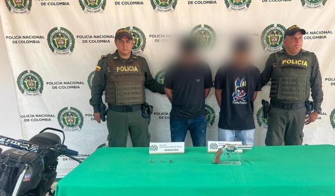 Personas capturadas-policías custodiando