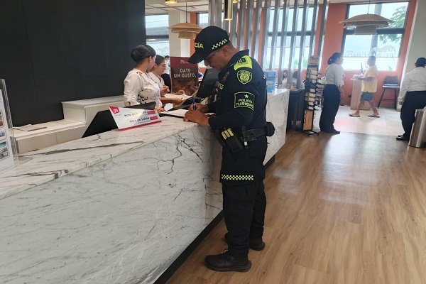 Policía de turismo dejando constancia de la revista realizada a la oficina de servicios turísticos 